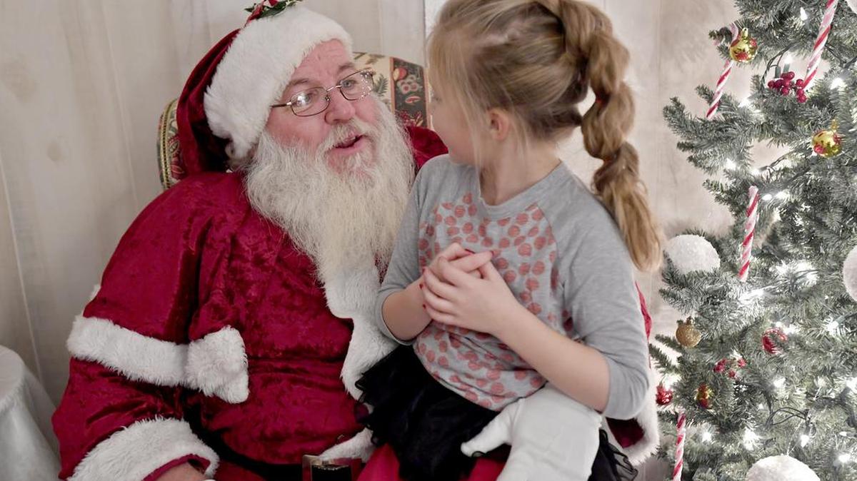 Elise Hoffman, 7, asks Santa for a Hatchimal on Tuesday in Santa’s house outside the courthouse in Bellefonte.