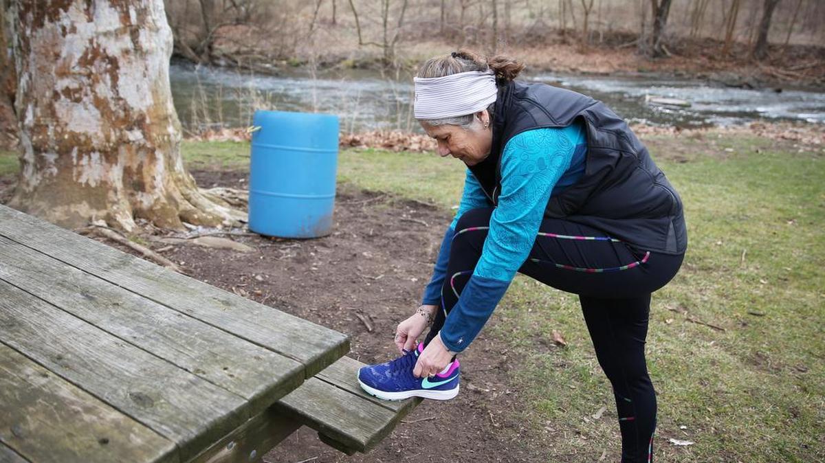 Lynn Moyer ties her shoes before going for a run on Feb. 21 at Fisherman’s Paradise in Bellefonte. Last fall, 62-year-old Moyer completed her first marathon.