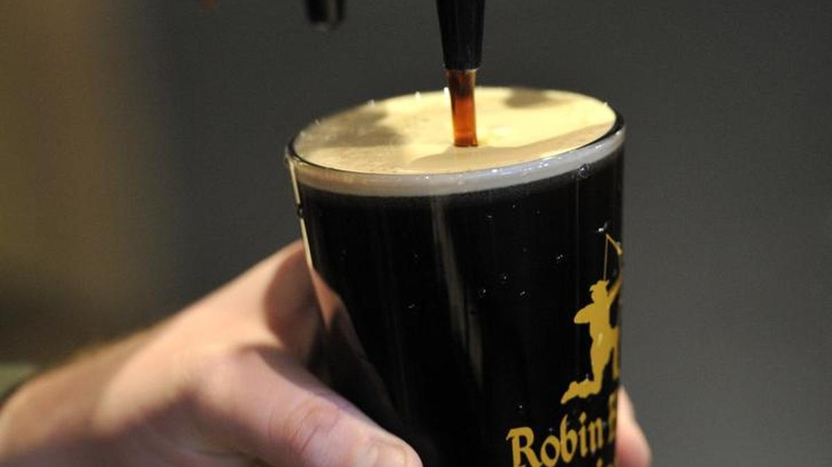 Chris Schell pours an F. Tuck porter from the tap at Robin Hood Brewing Co. in Bellefonte.