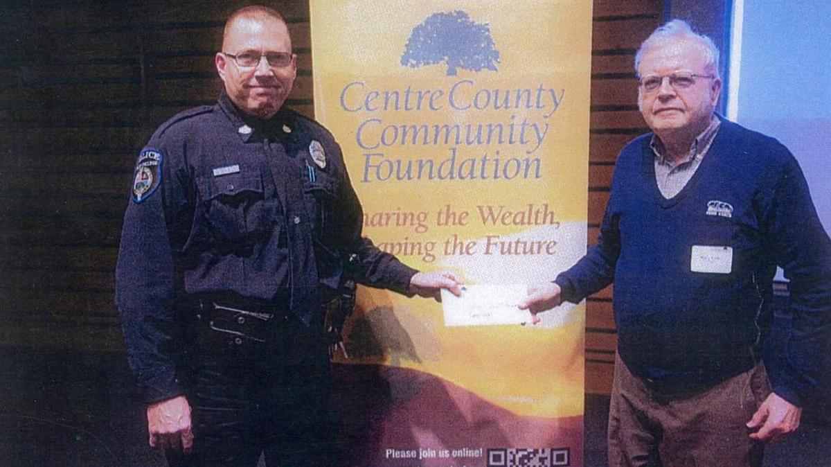 Barry Fisher, right, presents a check to retired State College police officer and Camp Cadet President Robbie Keen