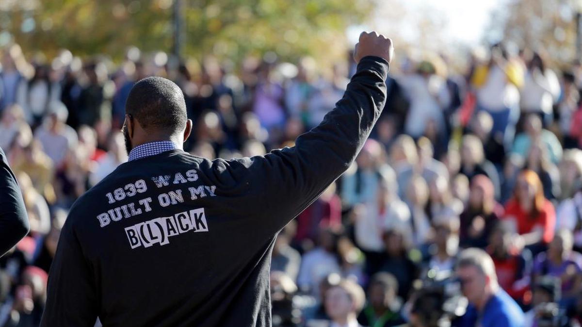 A member of the black student protest group, Concerned Student 1950, gestures while addressing a crowd following the announcement that University of Missouri System President Tim Wolfe would resign at the university in Columbia, Mo., on Nov. 9.