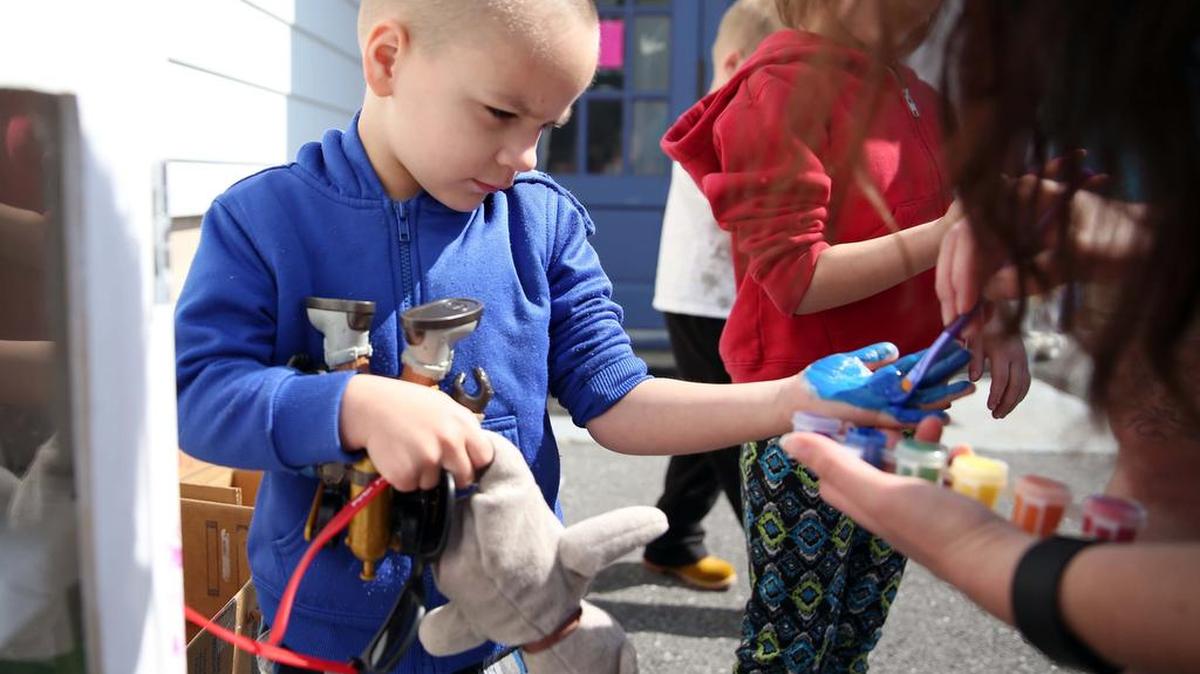 Samuel Cantara, 5, has his hand painted to put a palm print on the “Little Pantry” armoire on April 15 at the Houserville United Methodist Church.