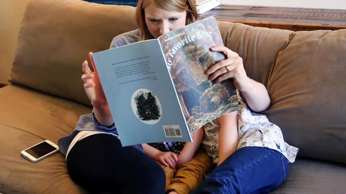Lydia Rex reads a book to her children on Tuesday in State College.