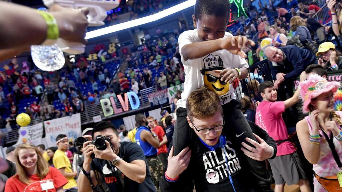 Samir Norton and dancer Sam Gilbert try to run from getting squirt by Carnell Bates during the 2018 Penn State IFC/Panhellenic Dance Marathon.