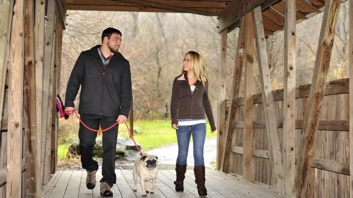 Nick Reyes and his girlfriend Emily Richards walk with their dog Frank in Slab Cabin Park on Wednesday, Dec. 2, 2015. They are planning to open a dog training facility in Boalsburg in the coming months.