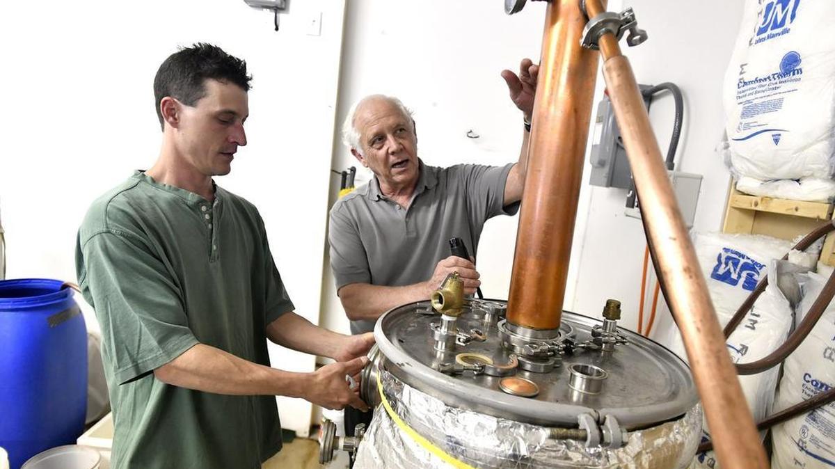 Dick Griffin, center, and his son Clancy Griffin work on the still, which distills alcohol out of mash. Griffin Whiskey recently moved from Rebersburg to Bellefonte.