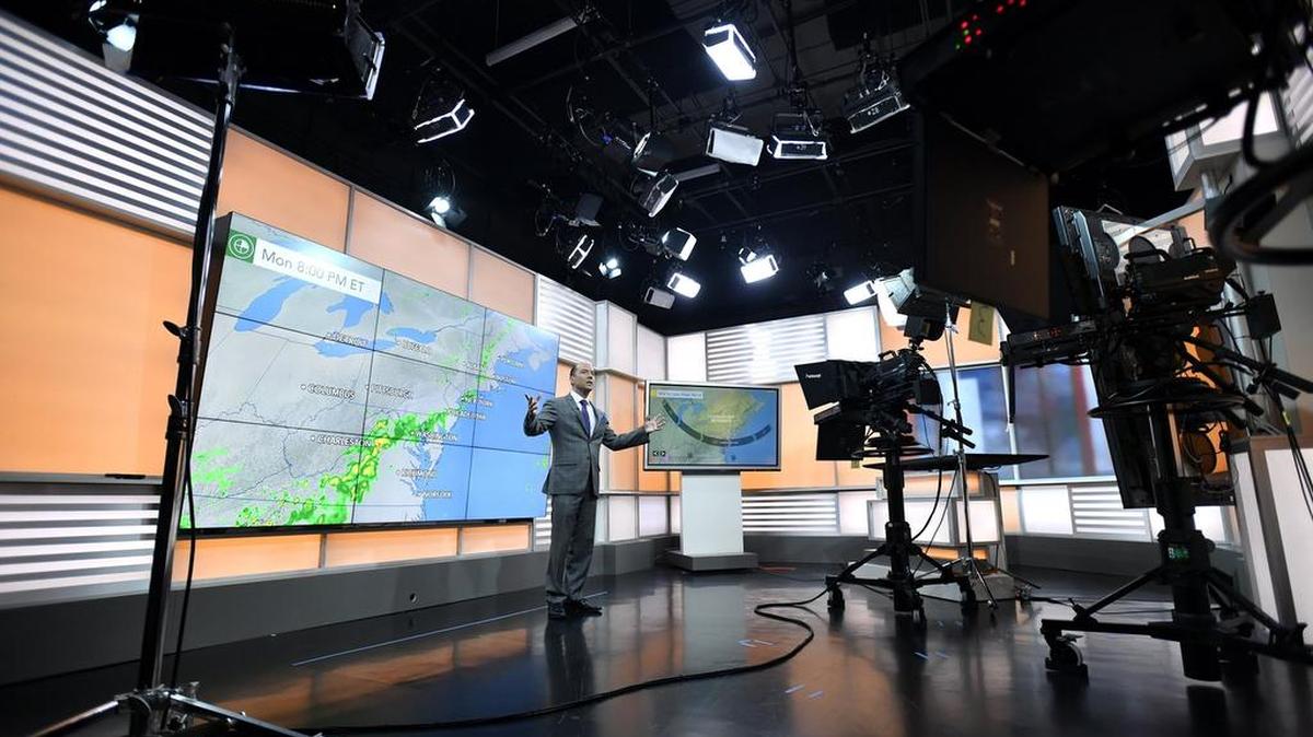 Chief meteorologist Bernie Rayno stands in front of the nine-panel video wall inside the studio on Friday. AccuWeather in State College has built a new television studio to support the AccuWeather Network.