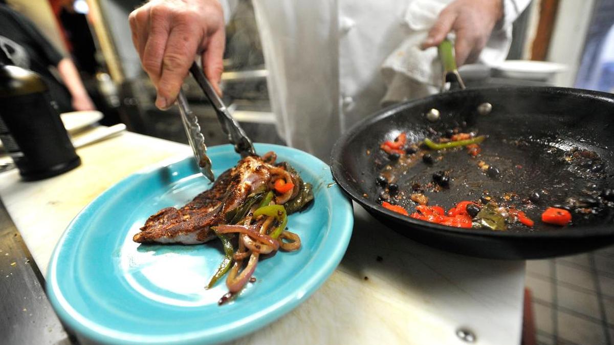 Duke Gastiger plates a classic jerk chicken in his kitchen. Chef and owner of Spats Cafe and Speakeasy Duke Gastiger is the coordinatior for the 2015 Passport on a Plate fundraiser benefitting Global Connections January 12, 2015.