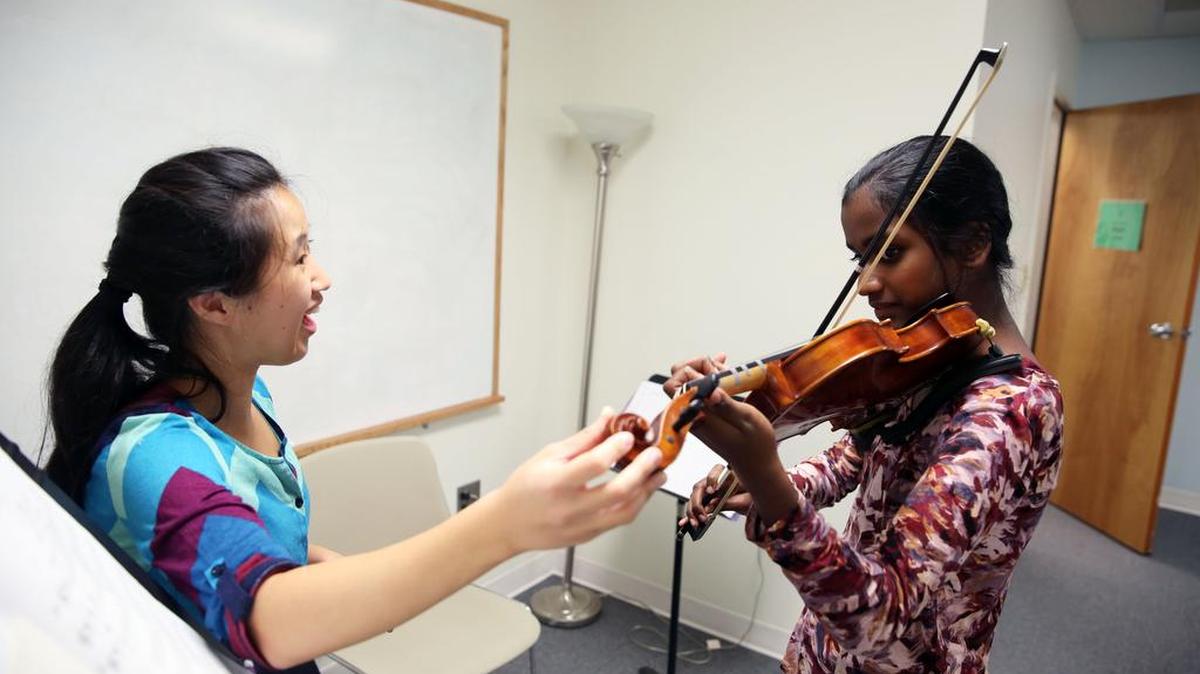 Hannah Lin, left, instructs Sumedha Srinivasan, 13, during a violin lesson on Tuesday at The Music Academy.