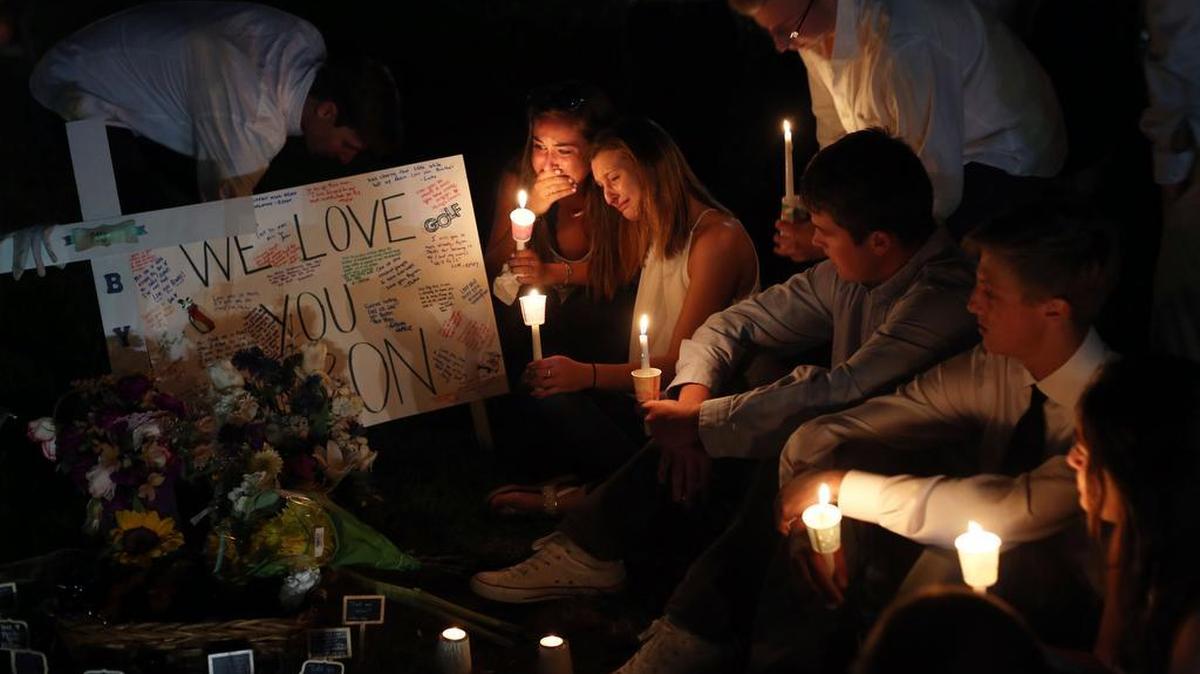 Friends and students gather to hold a candlelight vigil on Sunday in honor of Penn State student Byron Markle on the corner of Blue Course Drive State College. Markle was killed near that site in a single-vehicle crash Friday.