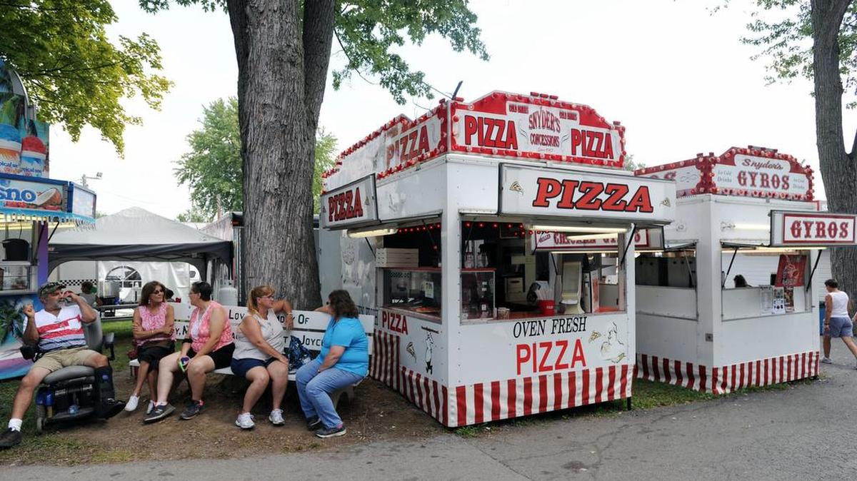 People sit next to a Snyder's concession stand Tuesday at Grange Fair.
