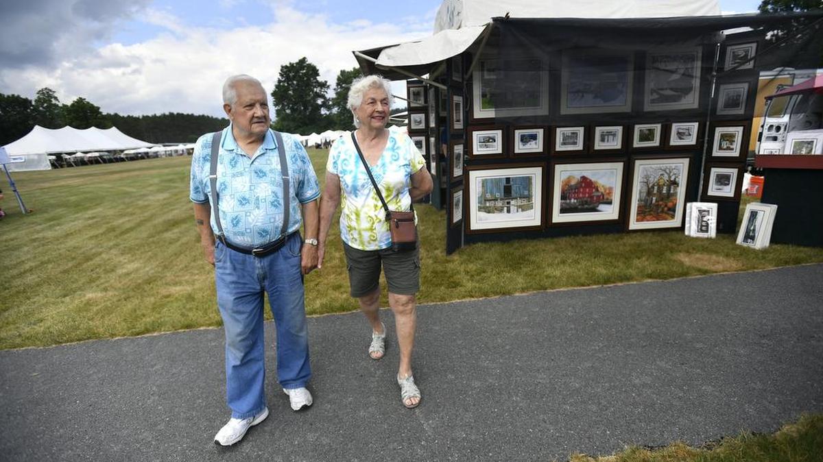 Phillip and Carol Myers, of Yeagertown, stroll through the People’s Choice Festival on Thursday. Hundreds of arts and crafts lovers braved balmy conditions on the opening day of the festival.