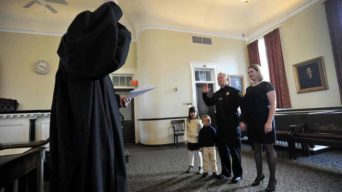 Judge Thomas King Kistler swears in Bryan Sampsel as Sheriff as his wife Ruth, and children Hannah and Cole stand with him. The Centre County elected officials swearing-in ceremony was held at the courthouse in Bellefonte, January 4, 2016.