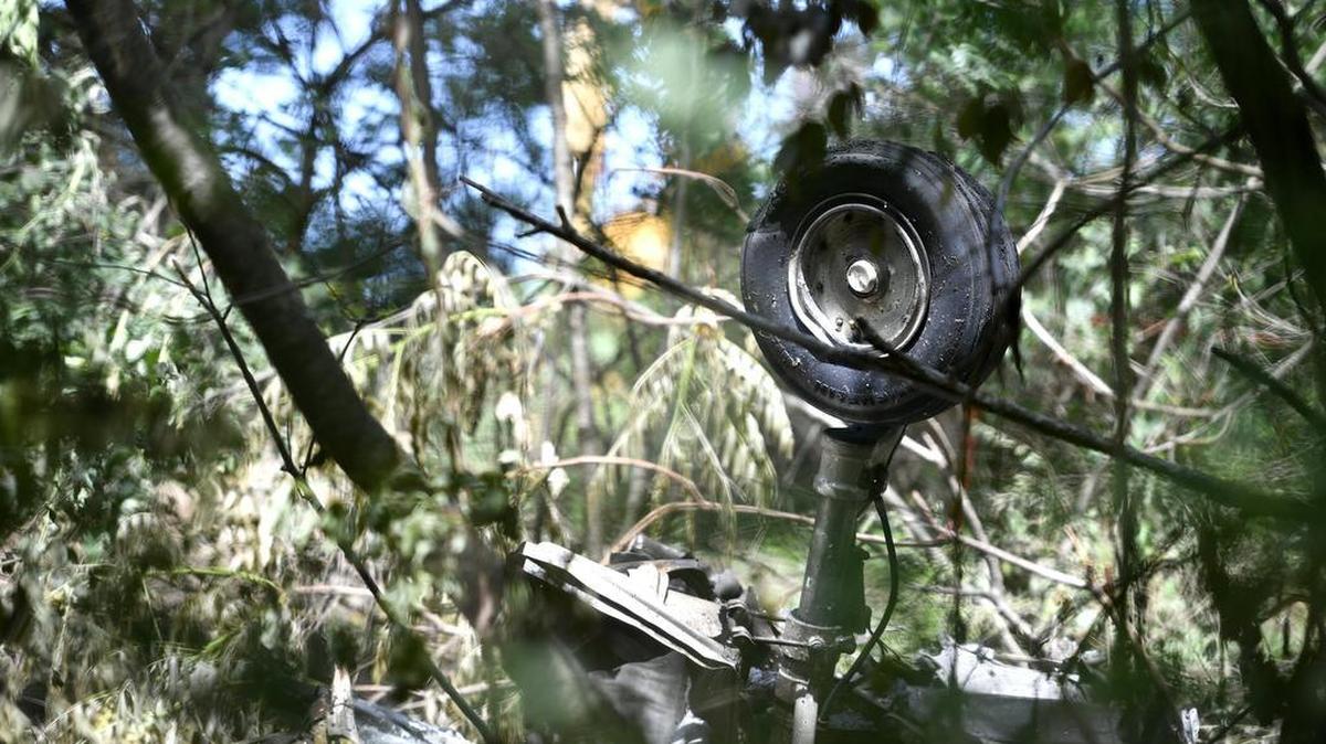 From behind the police tape line the landing gear of the aircraft can be seen through the dense woods. A plane approaching the University Park Airport from the east crashed into a wooded area on Thursday, June 16, 2016, killing two people.