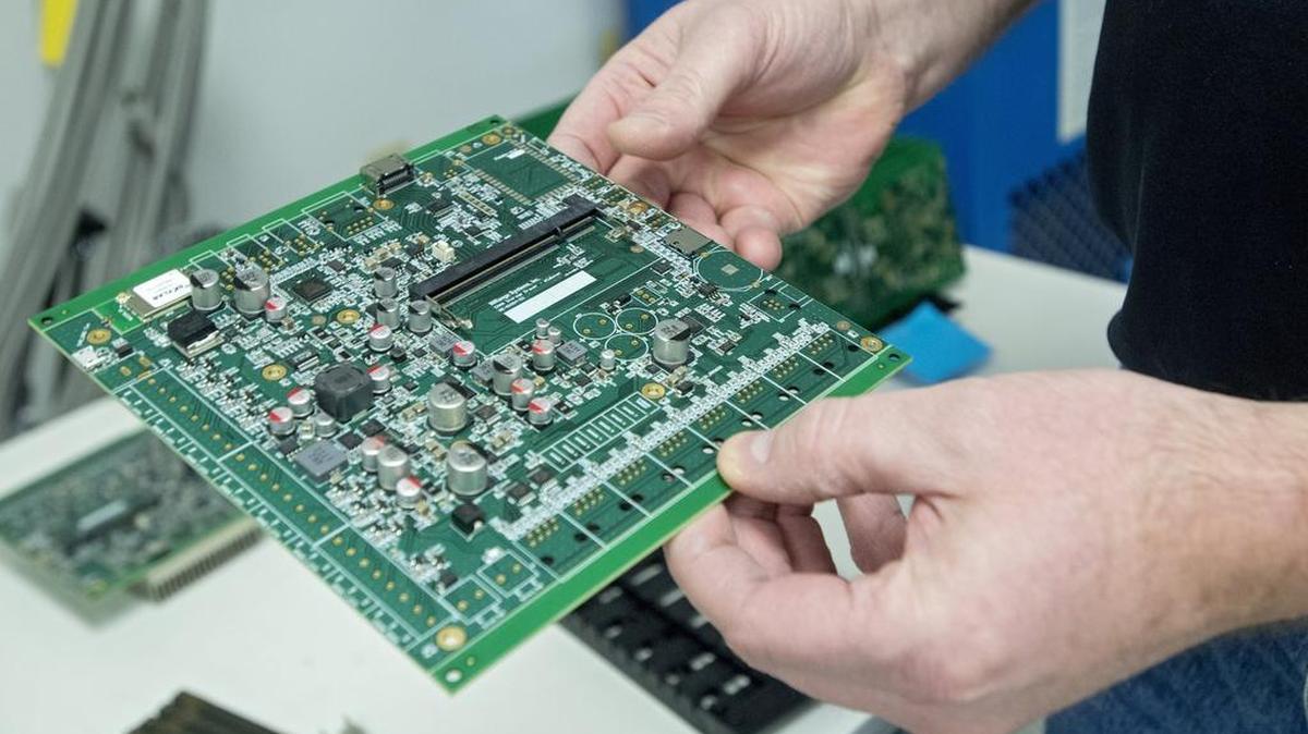 John Bonislawski, of Homeland Manufactoring Services, shows one of the company’s circuit boards on Jan. 11.