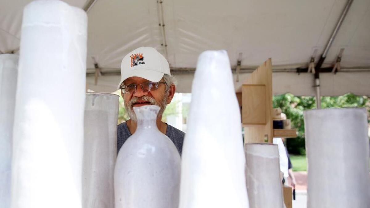 Mike Duermyer looks at the various works done by members of Penn State Ceramics during the Central Pennsylvania Festival of the Arts on Friday.