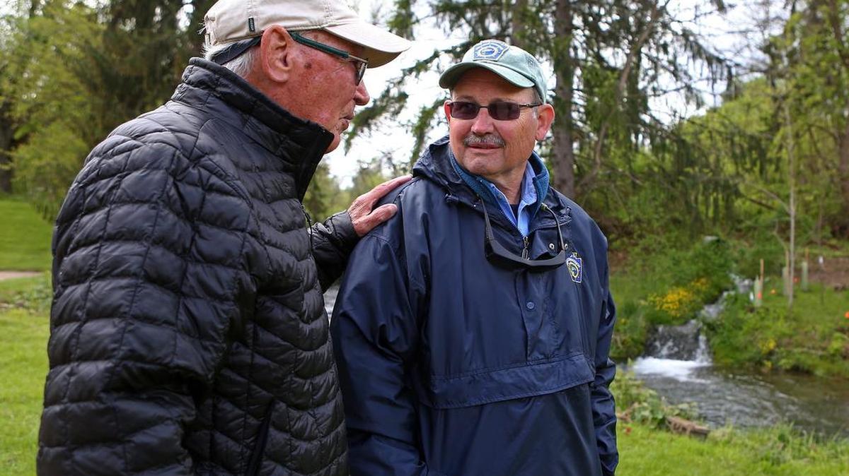 Founder of the Spring Creek chapter of Trout Unlimited Joe Humphreys speaks with the director of the Pennsylvania Fish and Boat Commission John Arway by the site of Humphreys’ Thompson Run stream improvement project during the dedication ceremony held at the intersection of Porter Road and East College Avenue on Sunday, May 15, 2016.