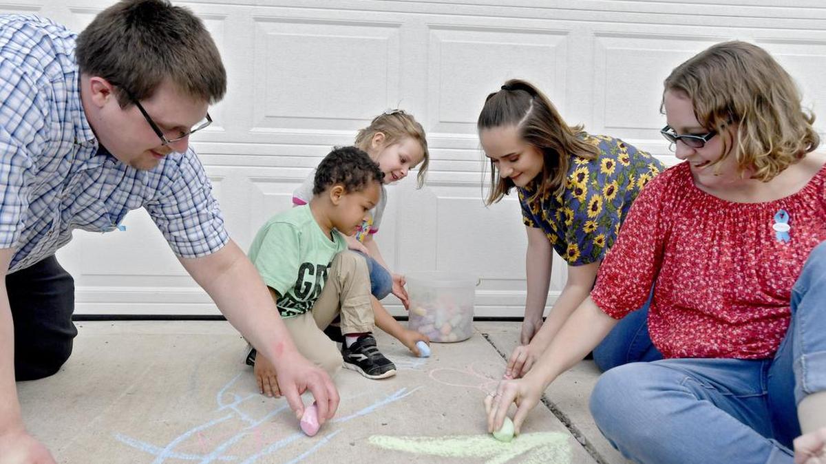 Paul and Hollie Zimmerman draw with chalk on Tuesday with their kids Derrick, 3, Emma, 4 and Destiny, 17 at their Bellefonte home.