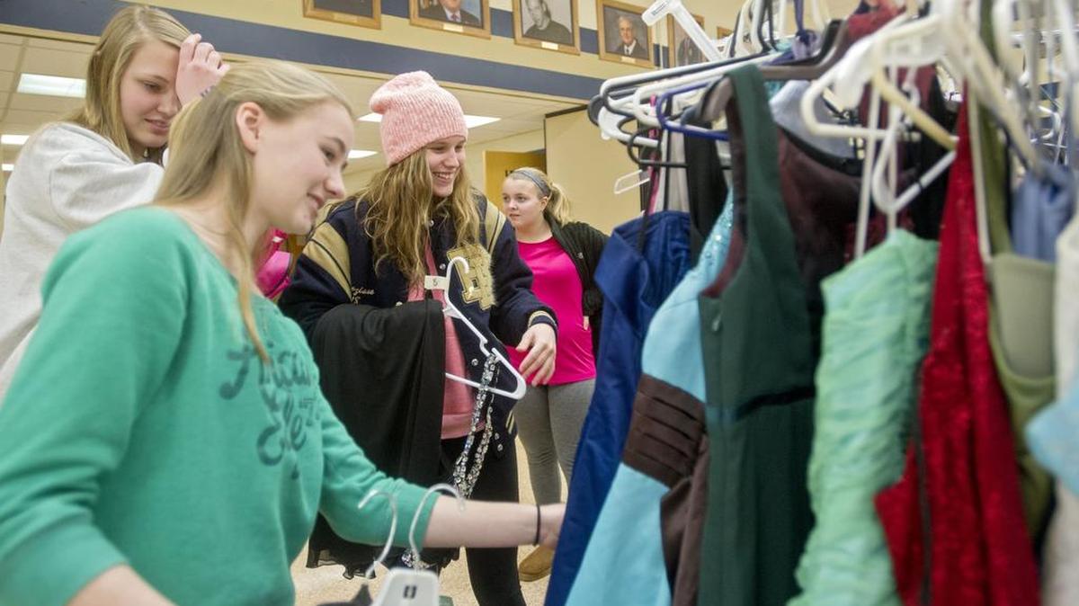 Friends Emma Murgas and Mariah Veneziano, center, browse the dresses during Bald Eagle Area's 4th annual dress event on Friday, February 12, 2016.
