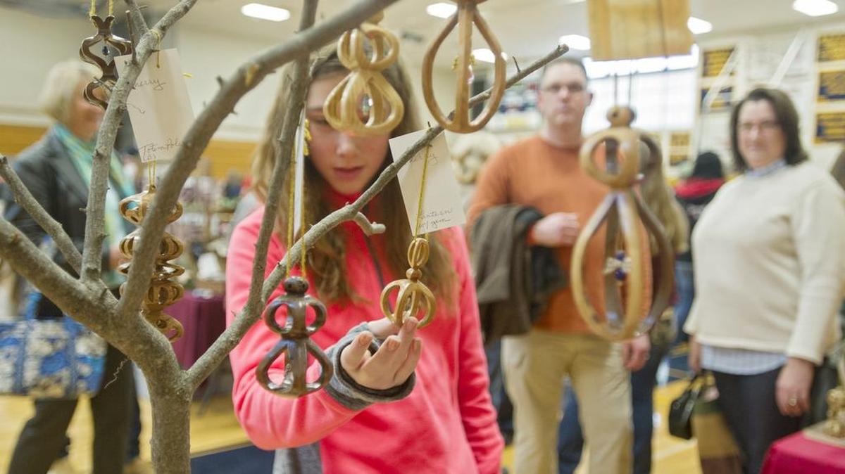 Visitors admire the hand made 3-D wooden ornaments by Bill O’Donald during the Bald Eagle Area annual craft fair on Saturday.