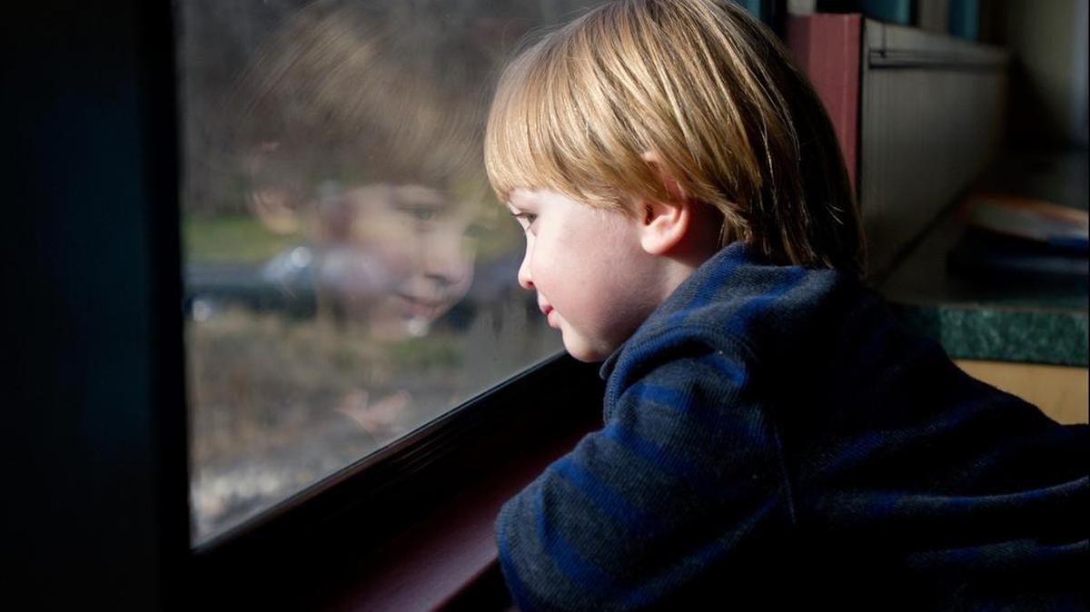 Ludden Riley, 2, looks out the train car window as holiday music plays.