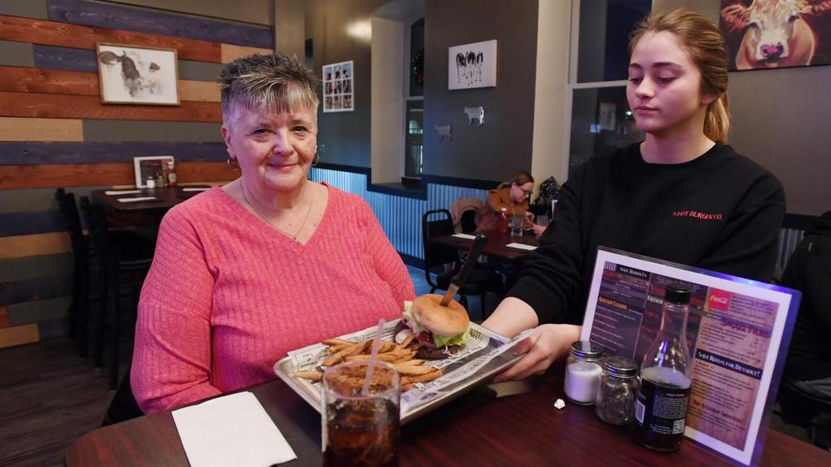 State Burger Co. waitress Amanda Barnhart hands Ellen Noll her burger Friday, Jan. 5, 2018 at State Burger Co. in Bellefonte.