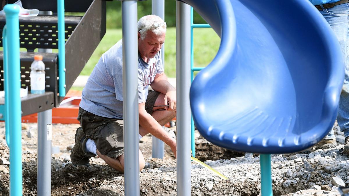 Bob Belinda, president of the Builder’s Association of Central Pennsylvania, measures concrete Friday for the installation of a playground in Beaver Farms, an affordable housing development in Bellefonte.