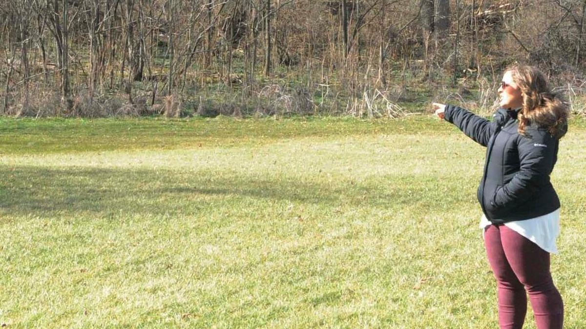 Bellefonte Area High School teacher Myken Poorman stands in the area where she and students plan to plant a garden in a few weeks. She points out the area where a pathway will be constructed, leading down the hill from the high school.