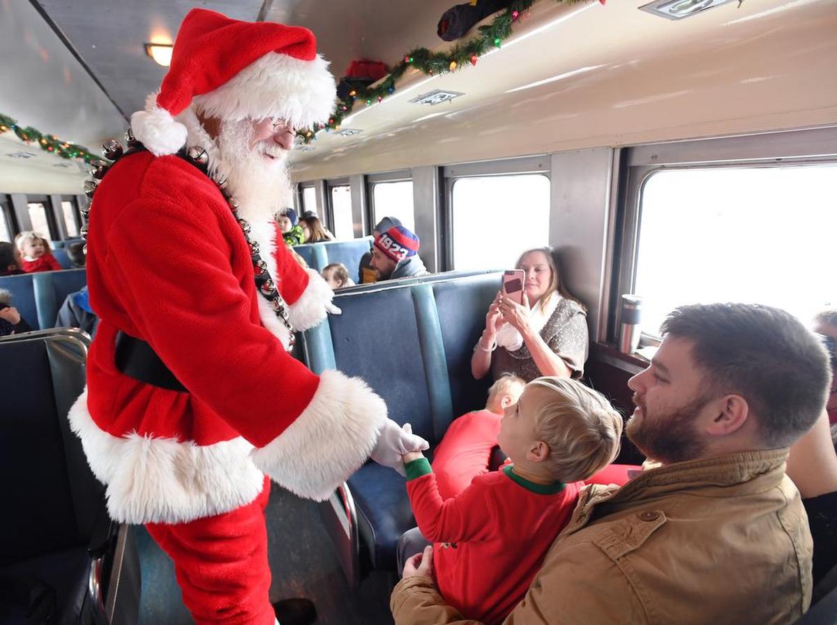Santa walks through the train cars during the Santa Express train ride Saturday, Dec. 16, 2017 in Bellefonte.