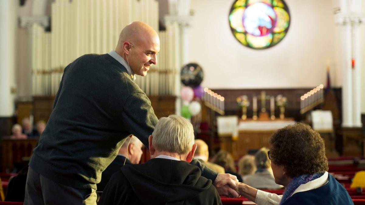 Pastor Chris Passante greets parishioners during a service celebrating the 200th anniversary of Trinity United Methodist Church in Bellefonte on Sunday.