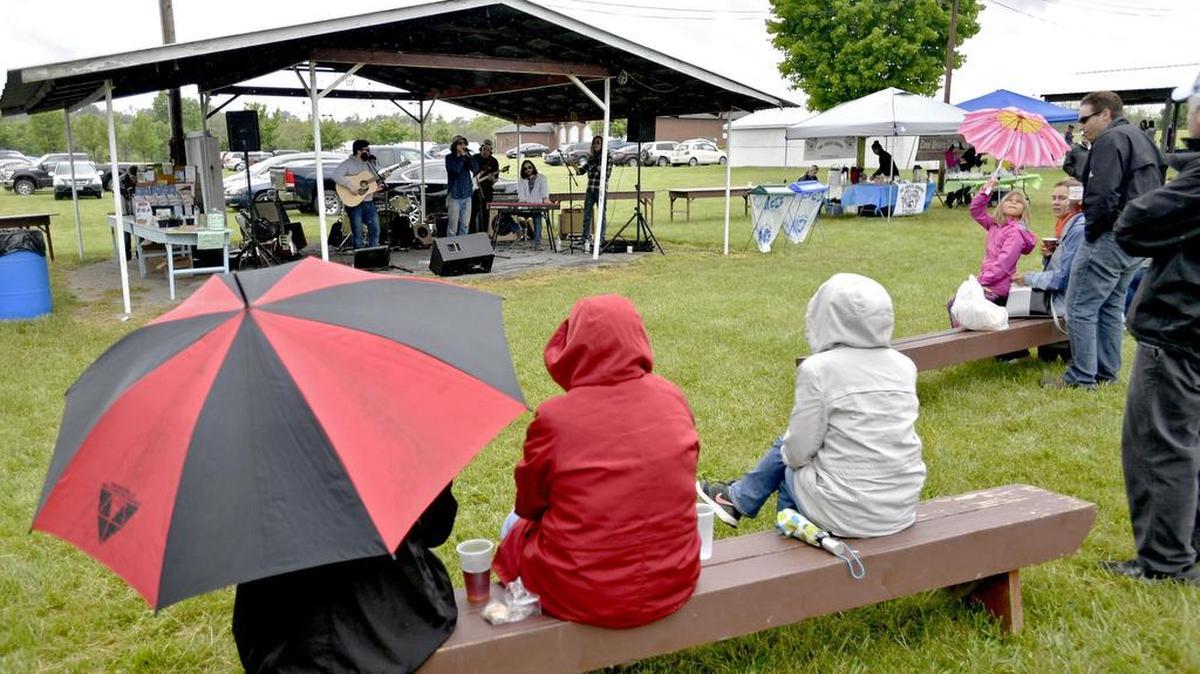 Folks brave the rainy weather to listen to The Tommy Roberts perform during Festa-Nic on Sunday on the Pleasant Gap Fire Company carnival grounds.