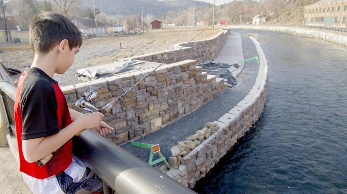 Matthew Loesch, 10, fishes off of Veterans Bridge on Tuesday, March 8, 2016. The Bellefonte waterfront project continues and community members are eager for the sidewalks to open.
