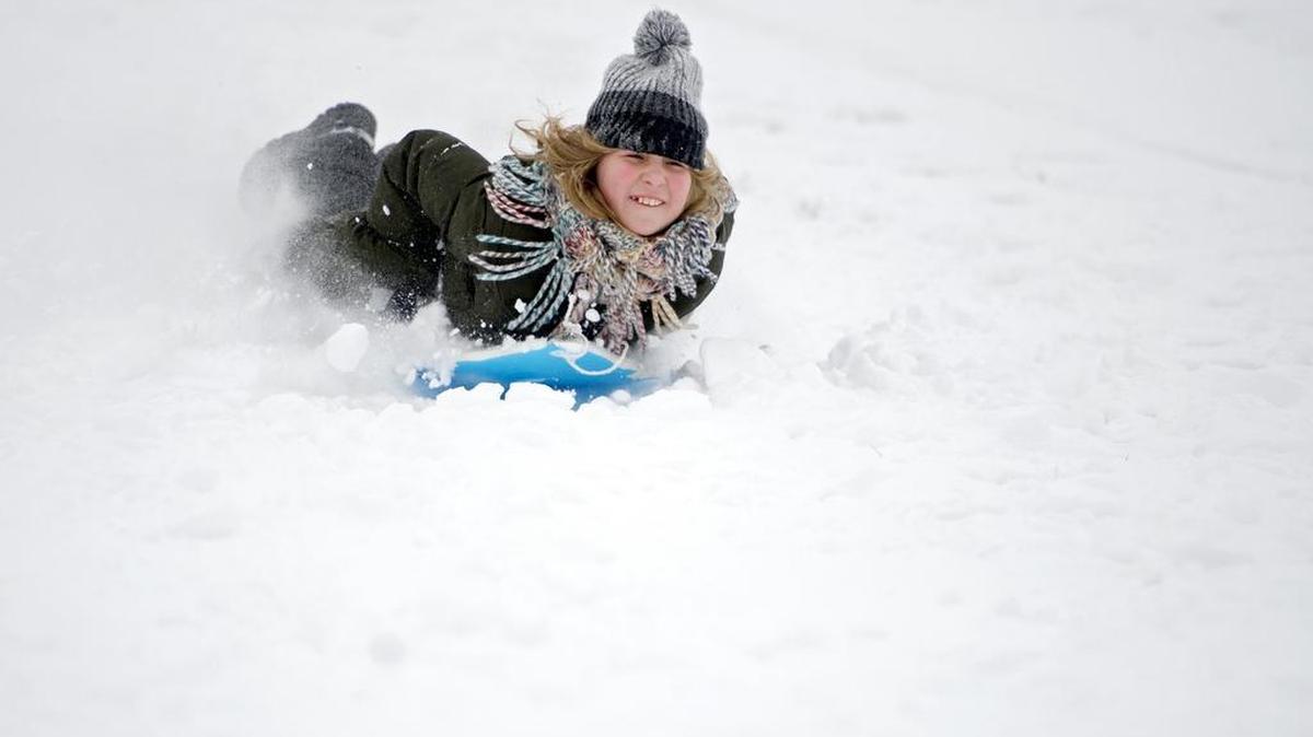 Mina Guillard, 11, sleds down the hill outside of Medlar Field on Saturday. Snow fall totals varied across the county.