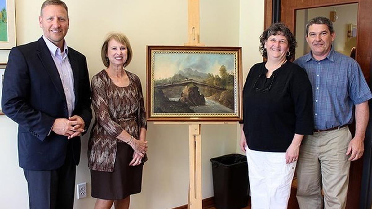From left: James A. Troha, president at Juniata; Teri Blanchard, interim vice president for finance and administration at Juniata; Staci Shuck, co-owner of Grove’s Office Supplies; and Jeff Shuck, co-owner of Grove’s Office Supplies, pose after signing an agreement to operate the renovated and renamed student store, Headwaters at Juniata. The name is inspired by the painting in between, called “Headwaters at Juniata,” by Thomas Cole. Cole is an early American painter who is noted for his wilderness scenes and for being a founder of the The Hudson River School of painters.