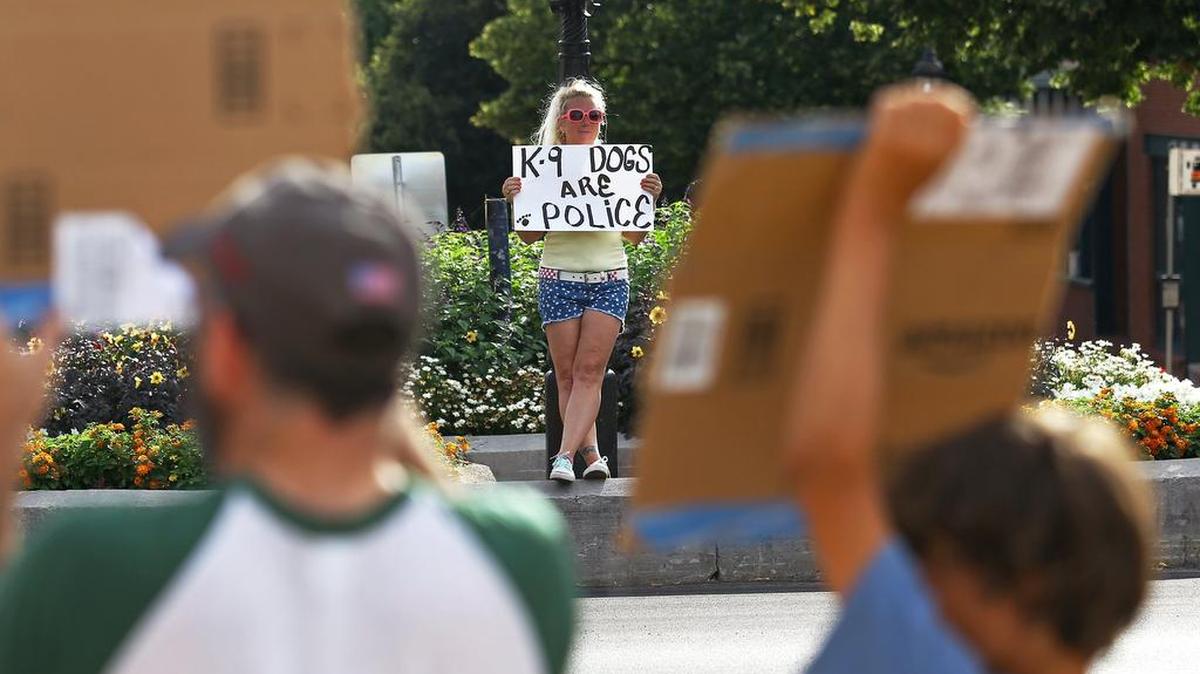 Lisa Shirk, of Bellefonte, holds a sign on South Allegheny Street on Monday, calling for justice for Totti, the Department of Corrections drug detection dog who died after being locked in a squad car for more than two hours.