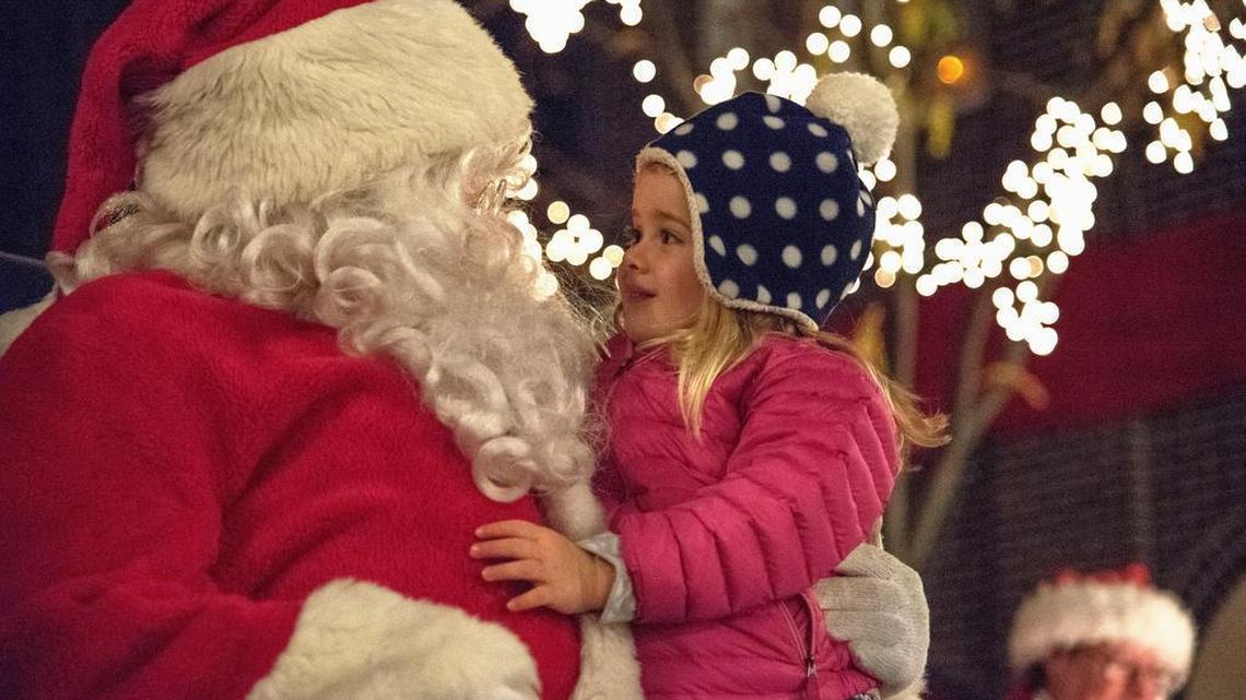 Kids take turns sitting on Santa's lap during the Christmas Tree Lighting Ceremony in downtown State College on Thursday, November 17, 2016.
