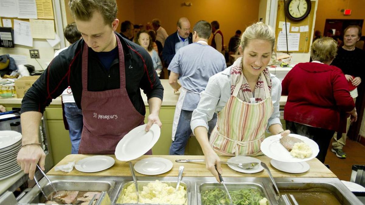 Charles Fishburn and Julia Bagby help serve dinner at St. Andrew’s Episcopal Church Community Cafe Christmas meal in 2014.