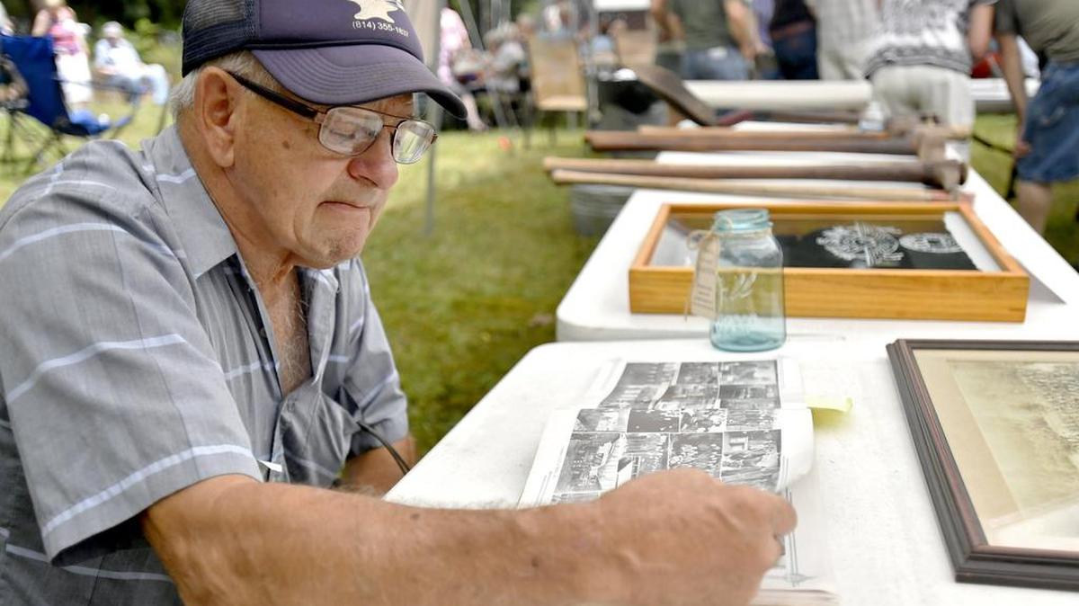 Richard A. Walker browses a book of photos from the CCC Camp S-63, Poe Valley, to try to find his cousin during the Civilian Conservation Corps Legacy Day on Sunday. Walker remembers picking his cousin up for weekends at home, before taking him back to camp for another week of work.