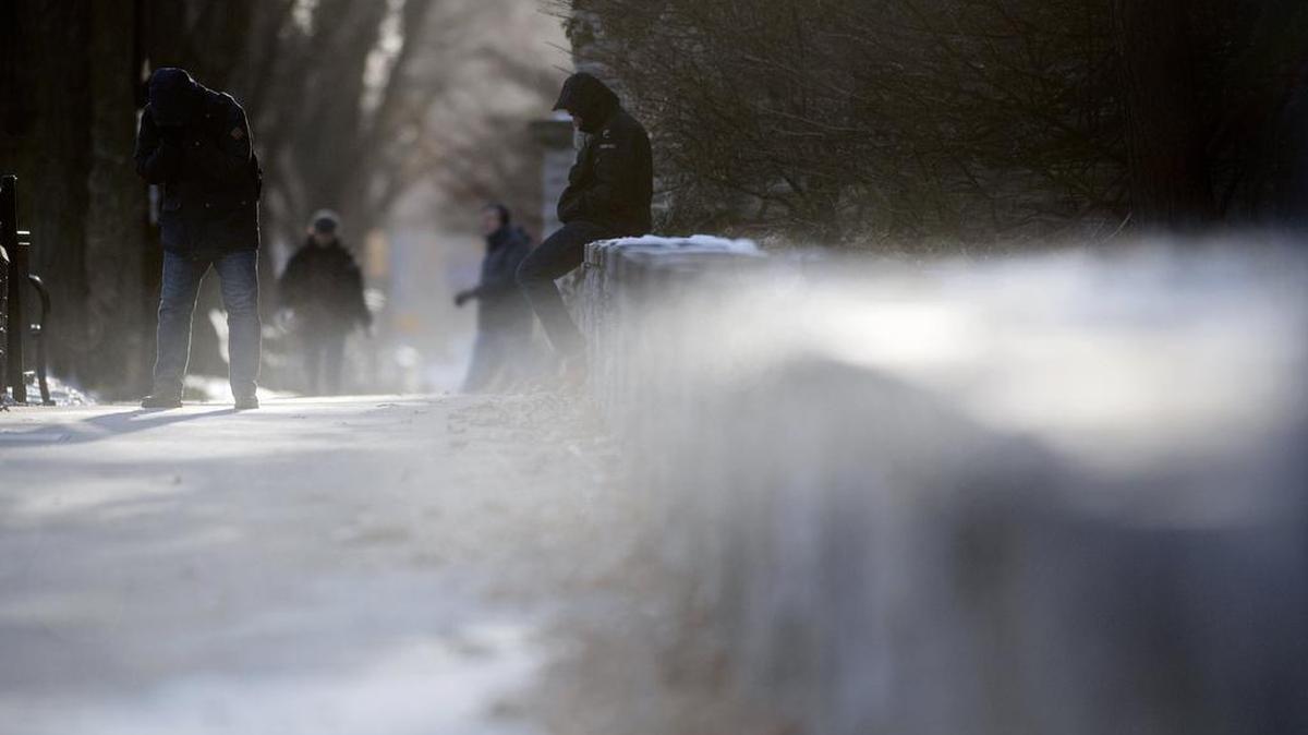 People shield themselves from the wind and cold as snow blows by the CATA bus stop on College Avenue on Thursday. Wind chill temperatures are expected to range from zero to minus 20 through Saturday evening.