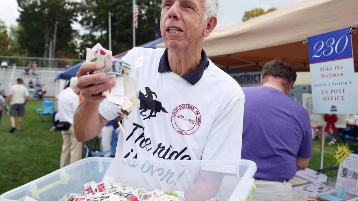 Mike Herr, aka “Mike the Mailman,” goes through a bin of old stamps on sunday during the Constitution 230 Celebration at Grange Park in Centre Hall. His booth highlighted Article 1, Section 8 of the Constitution — the post office.