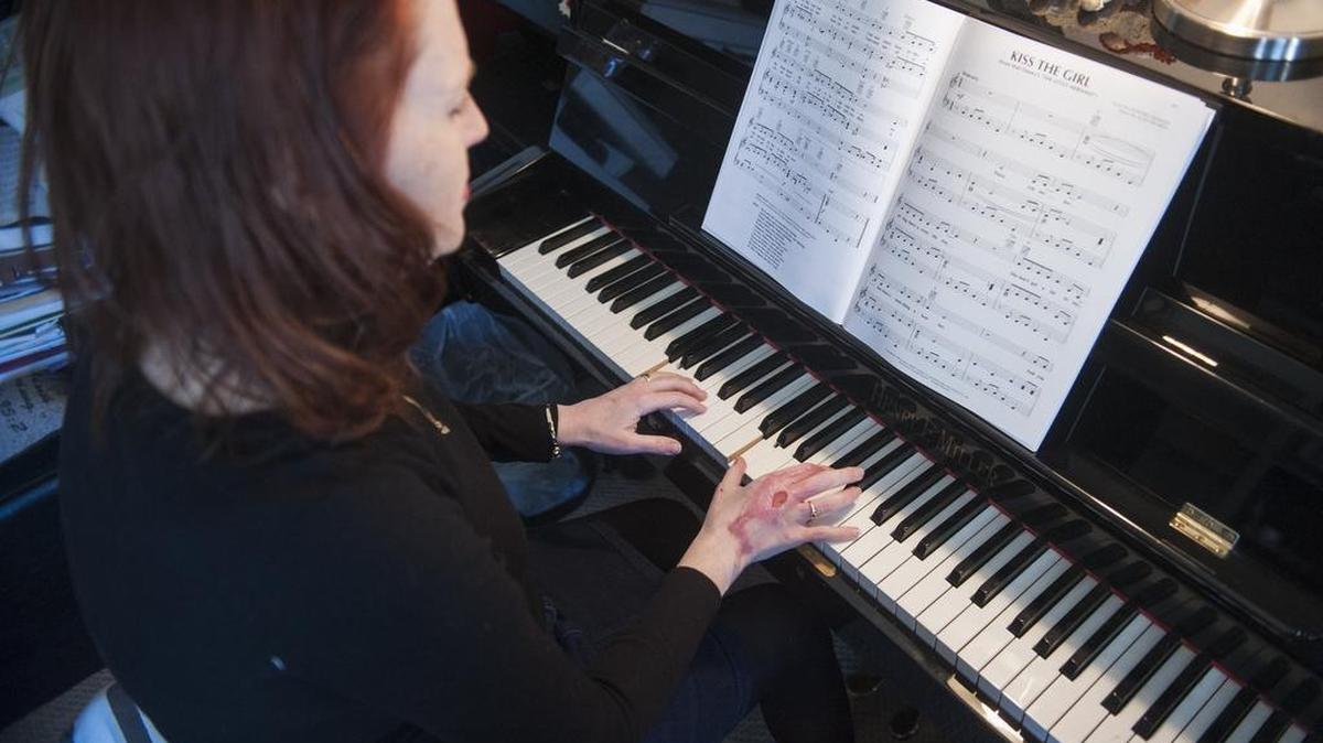Shannon Henry plays “Kiss the Girl” from Disney’s “The Little Mermaid” on the piano at her Spring Mills home on Feb. 21. Henry’s right hand was badly injured in a car crash in August. After having a finger reattached and skin grafts, Henry struggles to play and teach piano.