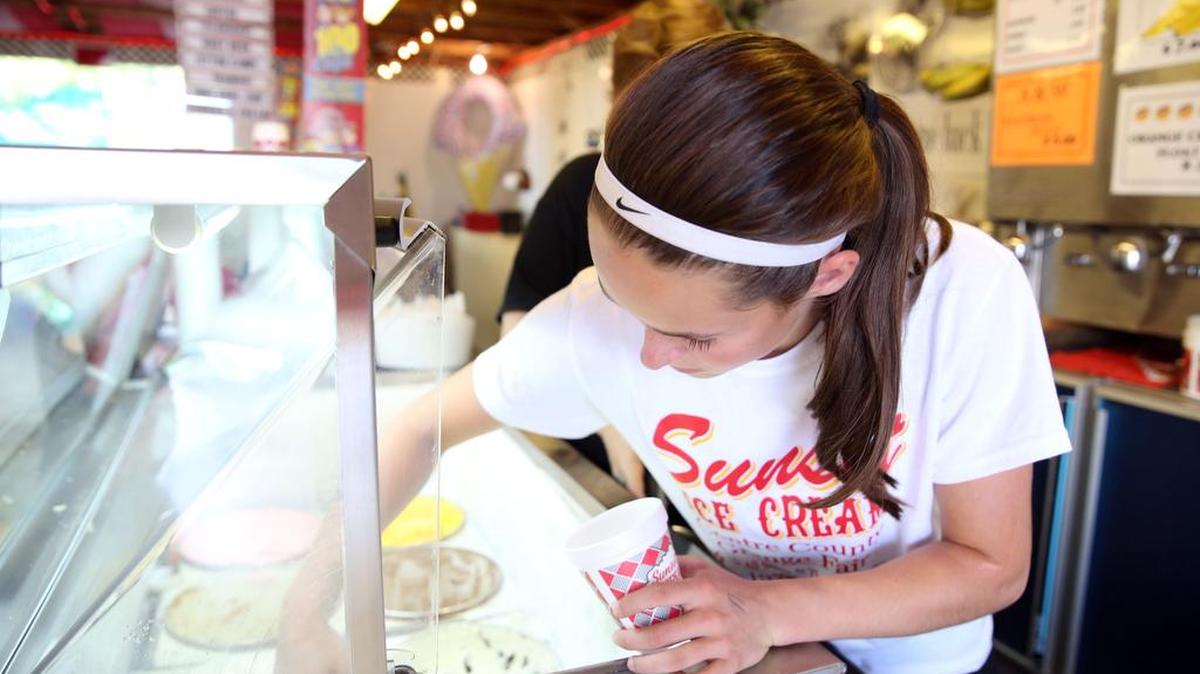 Lily Gardner scoops ice cream Tuesday at the Sunset Ice Cream Parlor at Grange Fair.