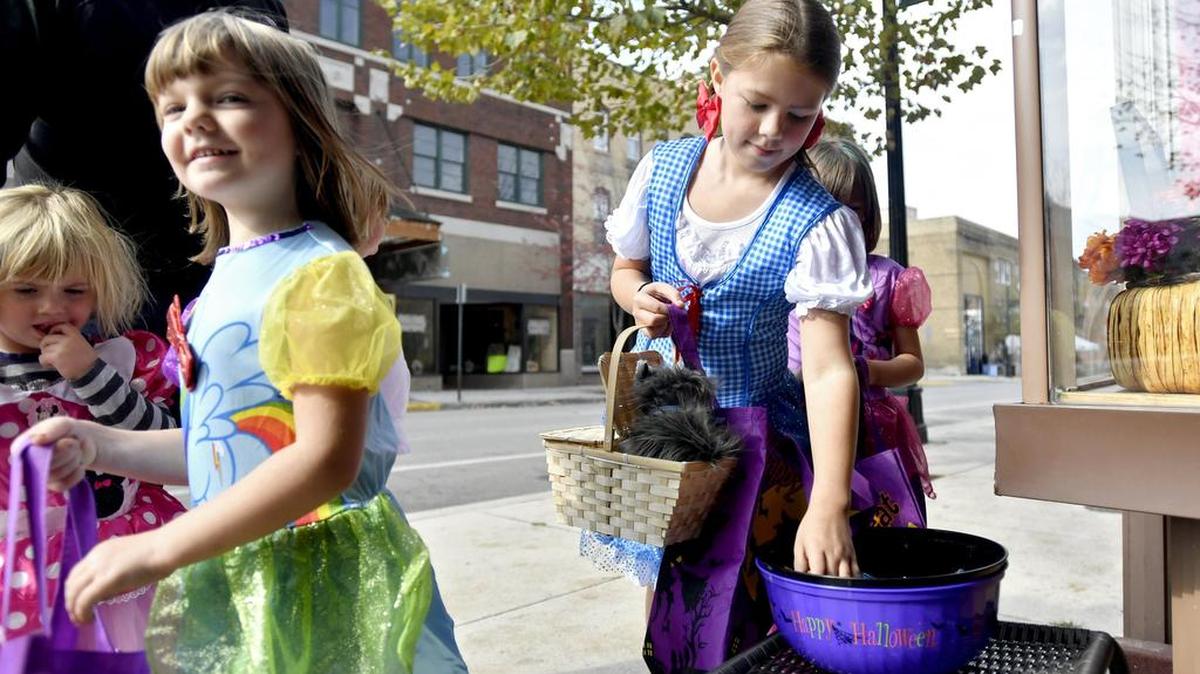 Dressed as Dorothy from “The Wizard of Oz,” Emily Olson, 9, gets a piece of candy on Saturday as she and her sister trick-or-treat at Diva’s Bling Boutique and Fashion Scrubs during the Philipsburg Harvest Festival.