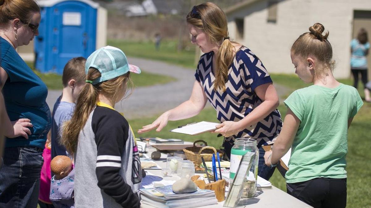 Mandy Maguffey, program coordinator at Millbrook Marsh, explains the scavenger hunt to families checking in on Sunday.