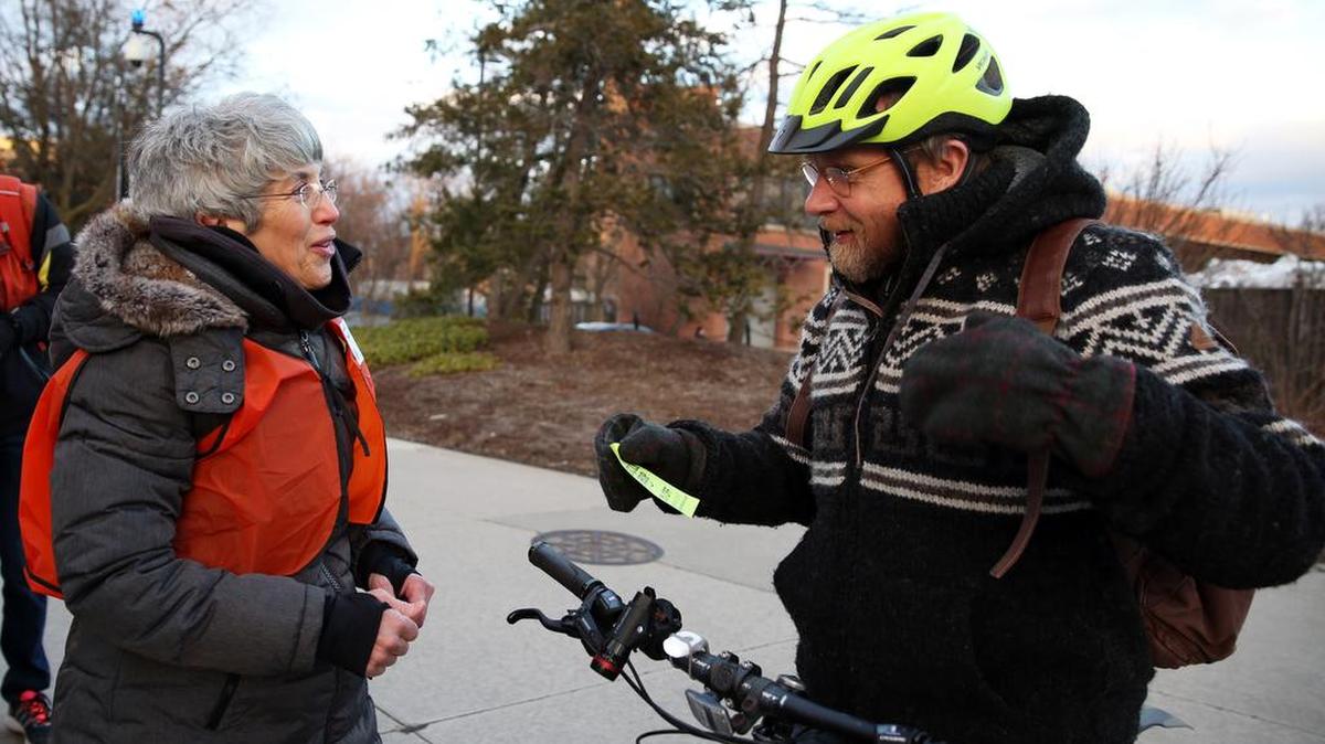 CentreBike volunteer Laura Brown gives Tim Wheeler a bicycle light and a coupon to The Bicycle Shop for the “Light Up the Night” bike safety event Monday in State College.