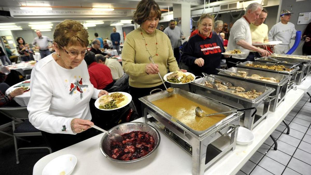 Irmgard Johnson, left, Linda McQuade, middle, and Noreen Davis, right, serve themselves Christmas dinner at the church. The Community Christmas Day Dinner at the State College Presbyterian Church is an annual event held December 25, 2015.