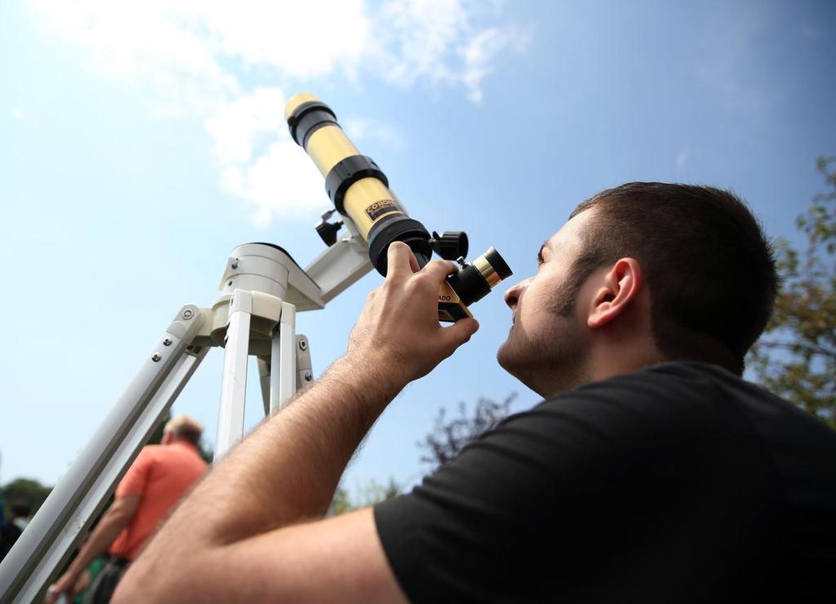 Alex Zerphy looks at the solar eclipse through a telescope on Aug. 21, 2017 at The Arboretum at Penn State.