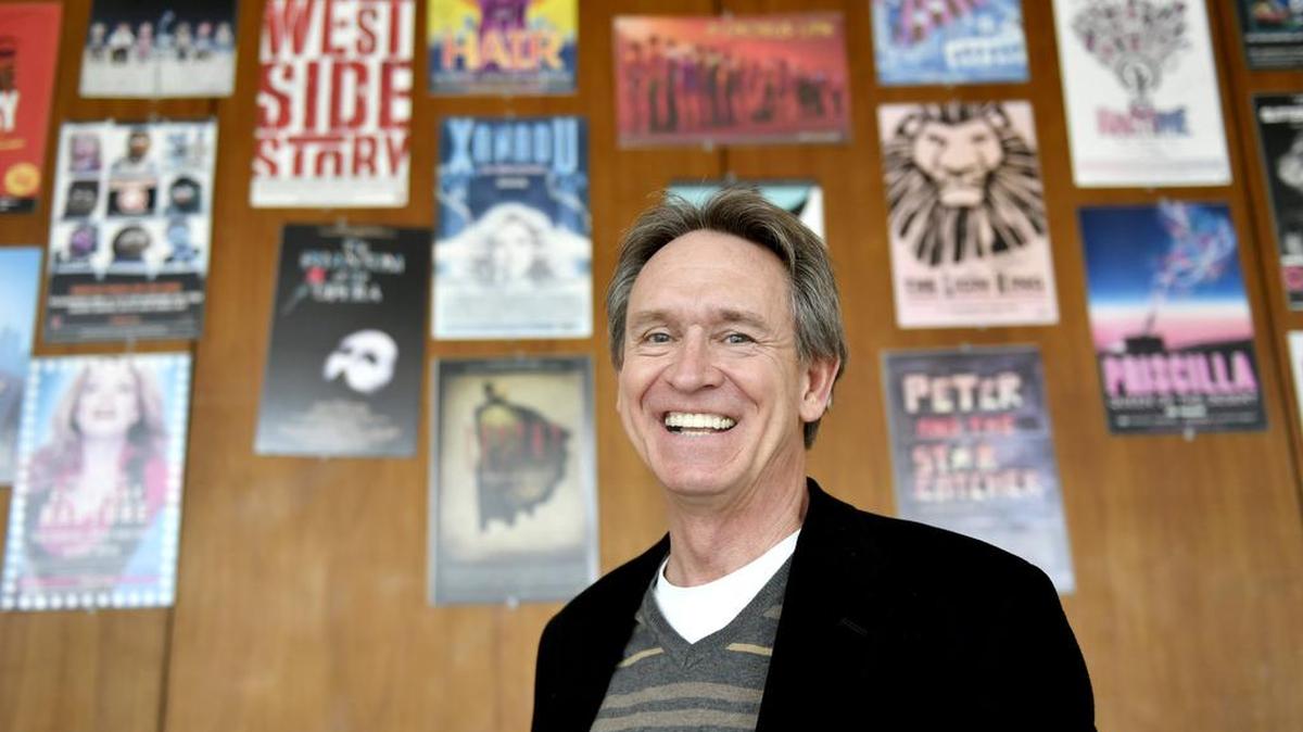 Penn State School of Theatre Director Dan Carter poses in the lobby of the Theatre Building, surrounded by posters of Broadway shows that Penn State alumni have been a part of. Carter is set to retire as School of Theatre director and producing director of Penn State Centre Stage in June.