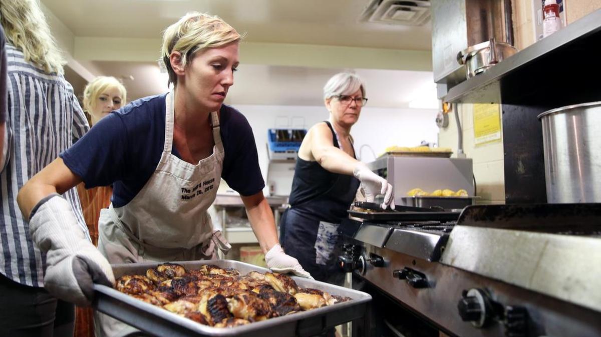 Rebecca Larsen takes the chicken out of the oven during Community Bite on Monday at St. Paul’s United Methodist Church in State College.