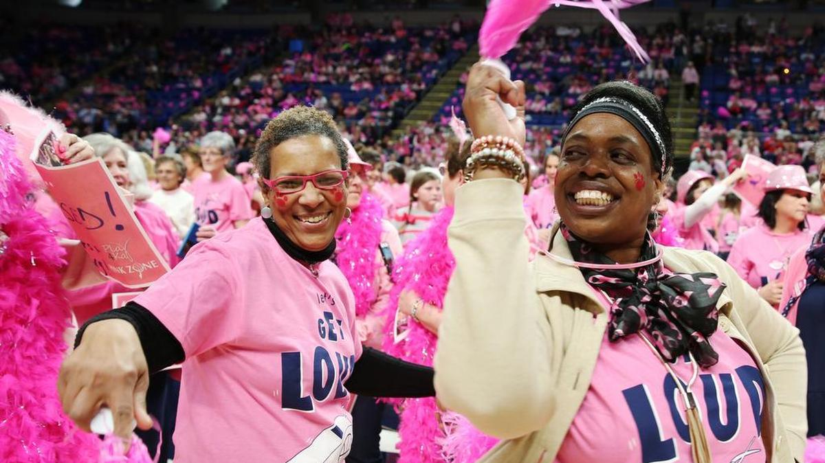 Sharlat Glenn, left, and Leslie Wilson dance during Sunday’s Play4Kay Game Benefiting Pink Zone at the Bryce Jordan Center.